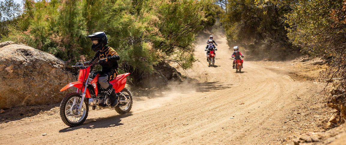 Honda CRF110F dirt bike in red with knobby tires and handlebar, suitable for beginner riders.