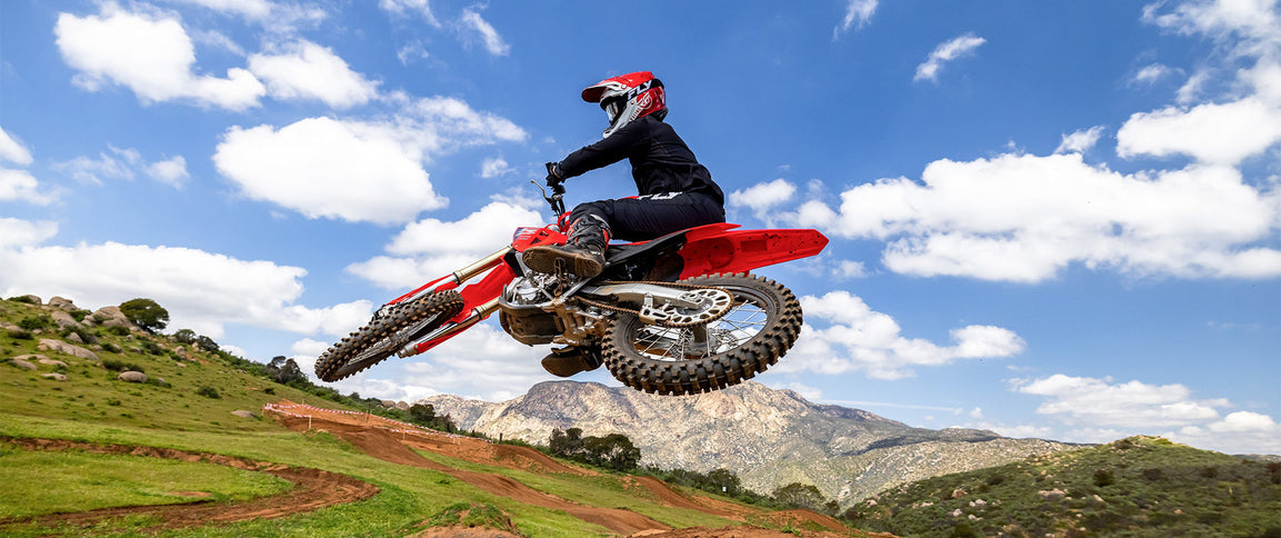 Honda CRF250R dirt bike with sleek black and red design, showing front view with rugged tires and detailed bodywork.