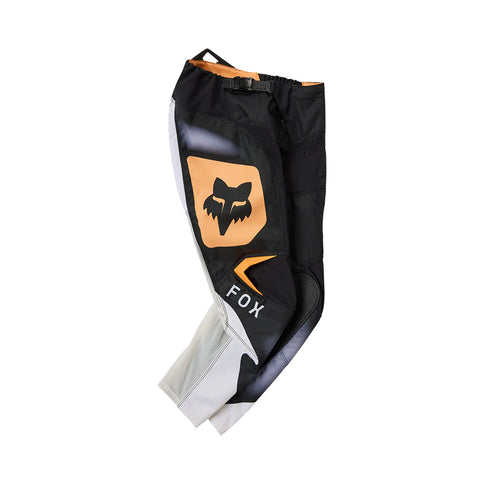 Black and white FOX 180 Noble Youth MX pants with reinforced knees and adjustable waist for motocross riding.