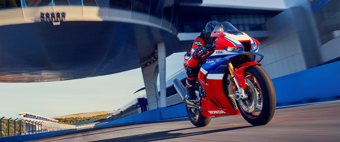 Honda CBR1000RR-R Fireblade motorcycle, front view showcasing sleek design and aerodynamic body in a vibrant red color.