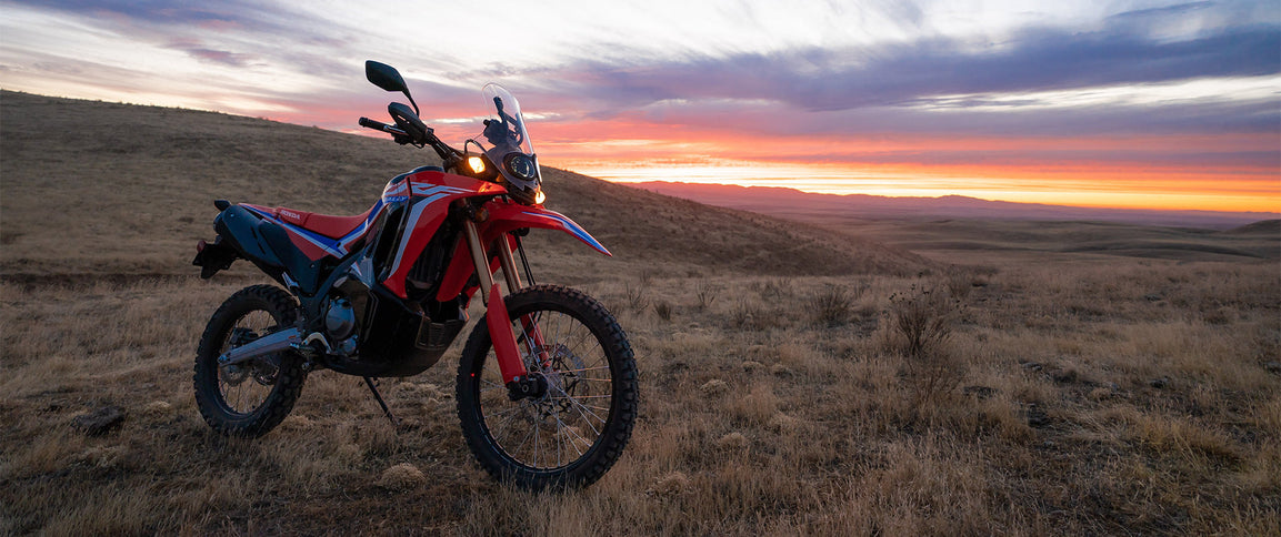 Honda CRF300R Rally off-road motorcycle with rugged design and rally-inspired features, shown in a detailed view.
