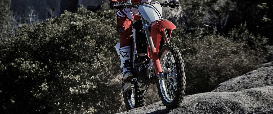 Honda CRF450RX motocross motorcycle showcasing its rugged design and off-road features in a dynamic outdoor setting.