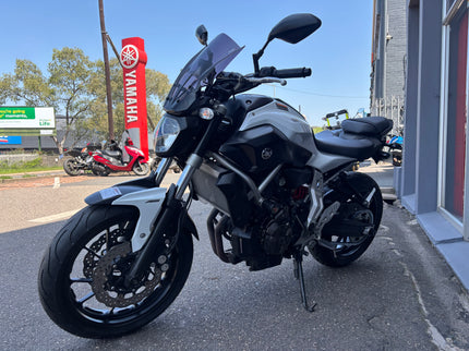 Used 2014 Yamaha MT 07 motorcycle with black body and sporty design, shown from side view.