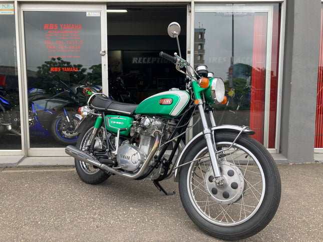 Yamaha 1970 XS 650 motorcycle with chrome details and vintage design, parked on a city street.