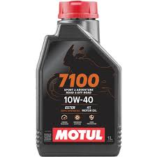 Bottle of MOTUL 7100 10W40 4T motor oil, 1-liter container with label indicating high-performance motorcycle engine oil.