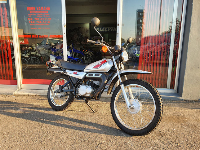 Used Yamaha 1980 MR 50 motorcycle, vintage mini bike with black and orange design and compact frame, displayed on a plain background.